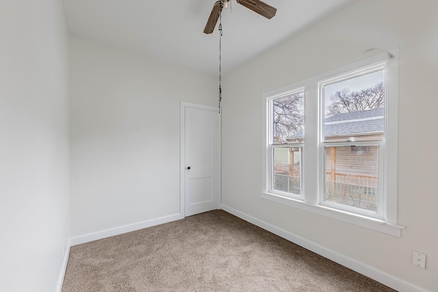 spare room with a ceiling fan, carpet flooring, and baseboards