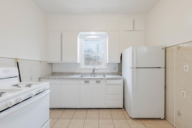 kitchen with light countertops, white appliances, light tile patterned flooring, and a sink