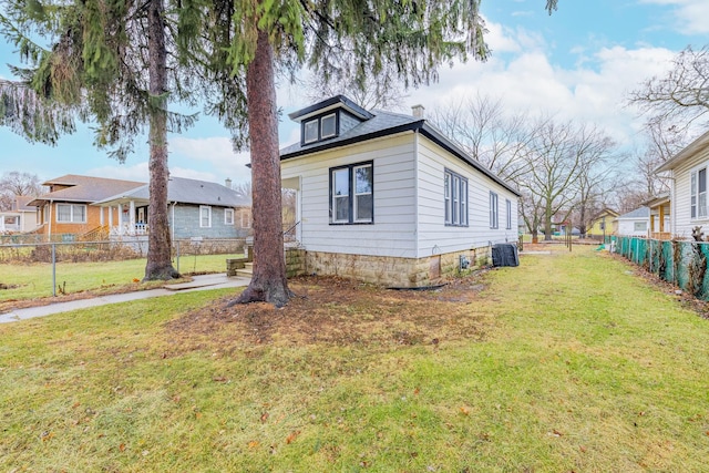 view of home's exterior featuring central air condition unit, fence, and a yard