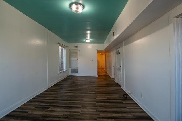 hallway with baseboards and dark wood finished floors