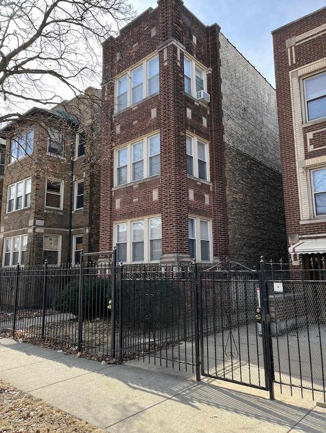 view of building exterior with a fenced front yard and cooling unit