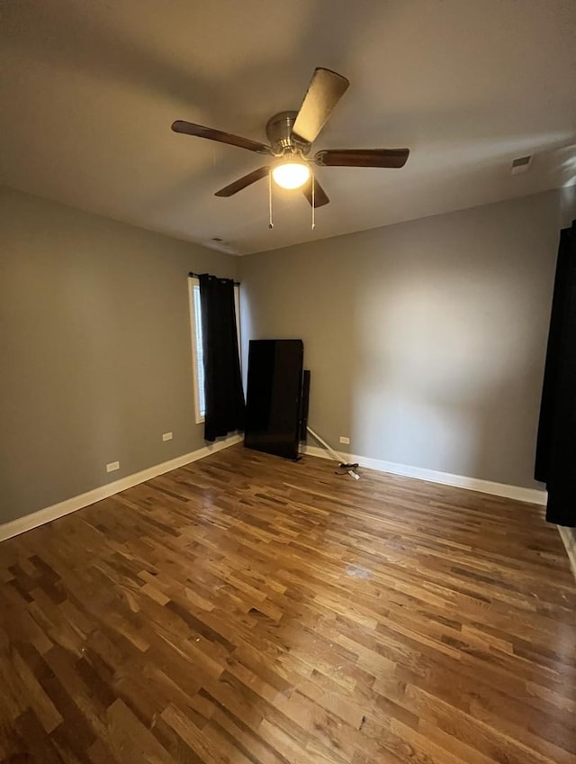 empty room featuring visible vents, baseboards, and wood finished floors