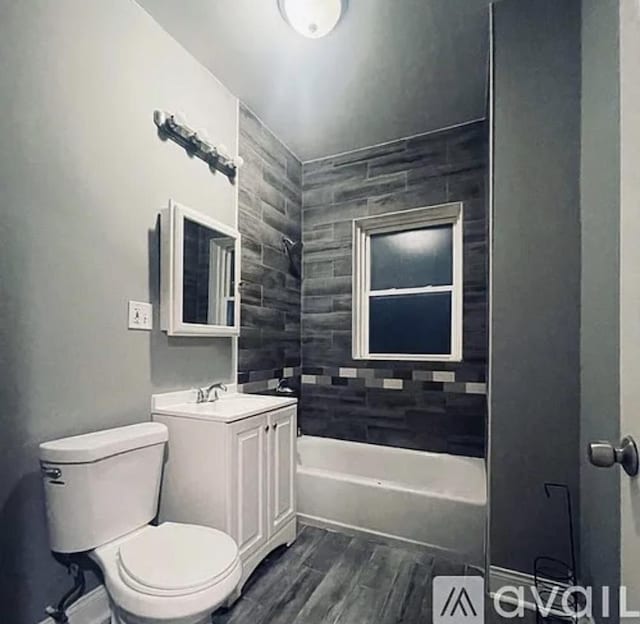 full bathroom with bathtub / shower combination, toilet, vanity, wood finished floors, and baseboards