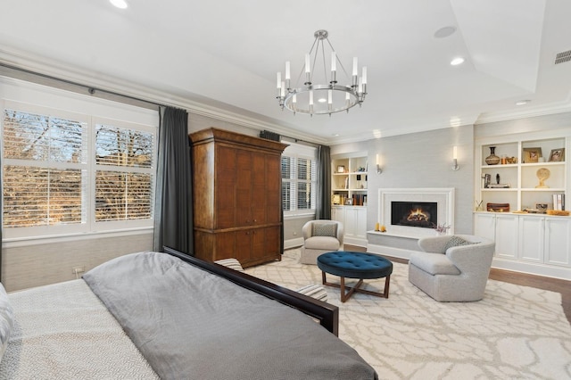 bedroom with visible vents, a raised ceiling, ornamental molding, a lit fireplace, and recessed lighting