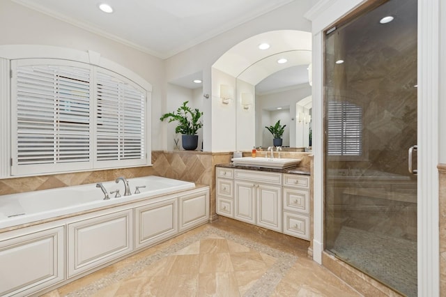 full bath with a stall shower, ornamental molding, a garden tub, vanity, and recessed lighting