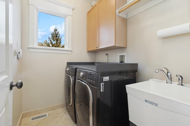 laundry area with light tile patterned flooring, washing machine and dryer, a sink, visible vents, and cabinet space