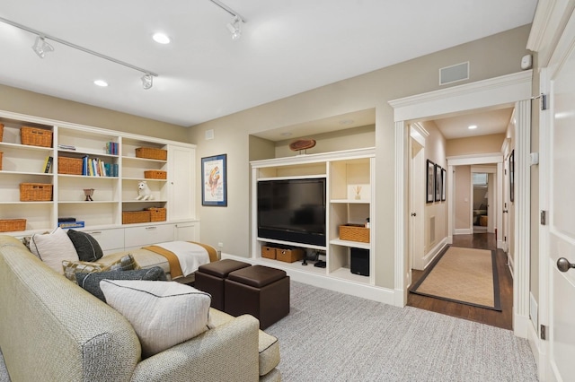 living area featuring rail lighting, visible vents, baseboards, and wood finished floors