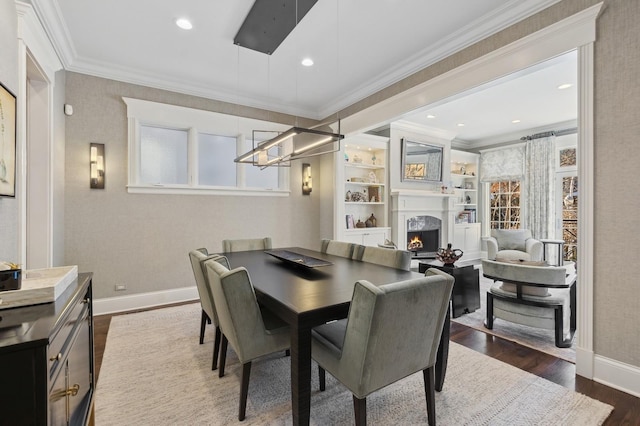 dining area with ornamental molding, a warm lit fireplace, baseboards, and dark wood-style flooring