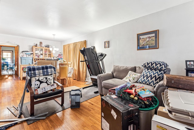 living area featuring hardwood / wood-style floors, a notable chandelier, and baseboard heating