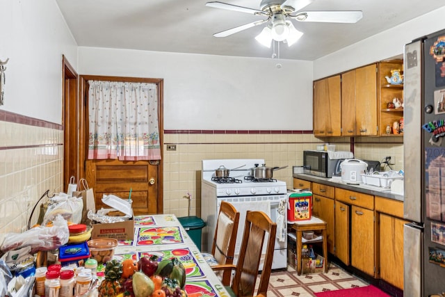 kitchen with open shelves, brown cabinets, appliances with stainless steel finishes, and ceiling fan