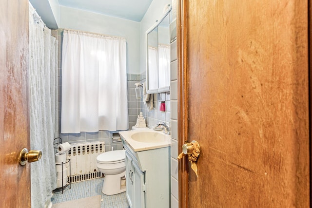 full bathroom featuring tile patterned flooring, radiator, toilet, vanity, and tile walls