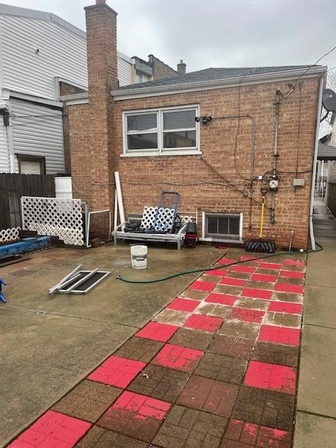 back of house featuring fence, a patio, and brick siding