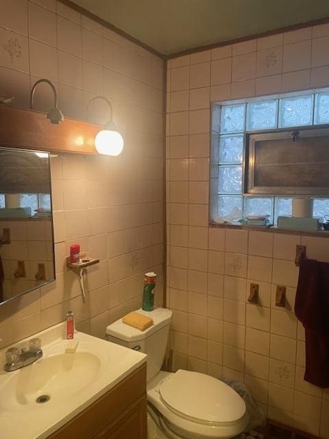 bathroom featuring tile walls, toilet, and vanity