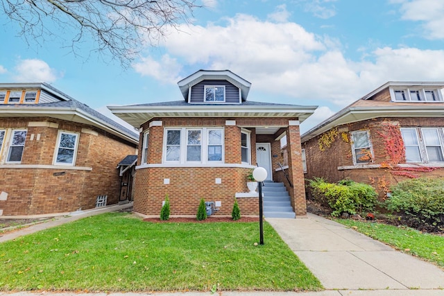 view of front facade with brick siding and a front lawn