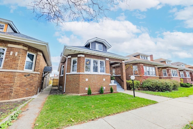 view of front facade with brick siding and a front yard