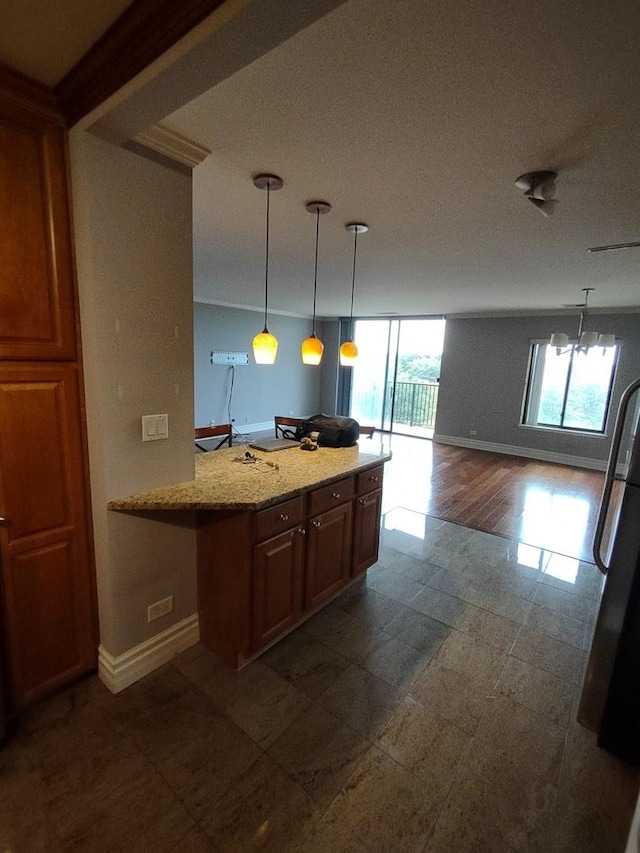 kitchen with freestanding refrigerator, baseboards, open floor plan, and decorative light fixtures