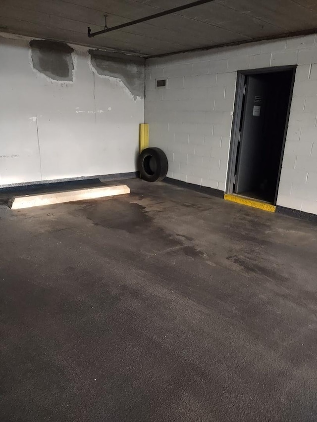 parking garage featuring concrete block wall and visible vents