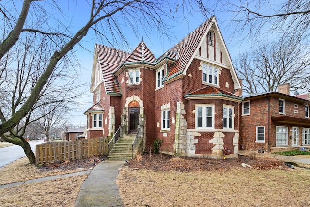 view of front of house featuring brick siding and fence