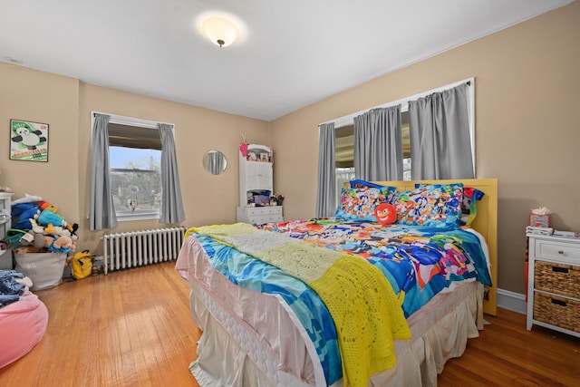 bedroom featuring radiator heating unit and wood finished floors