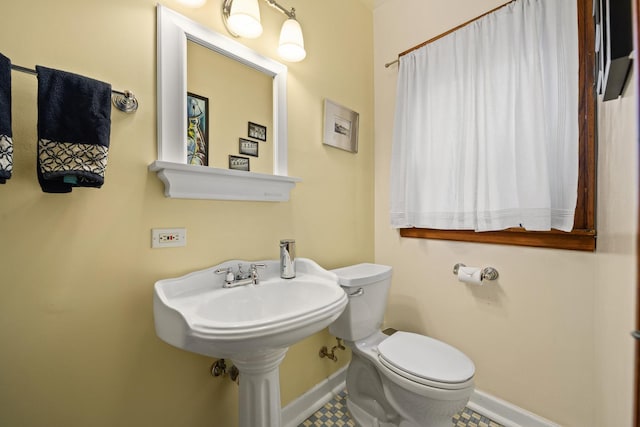 bathroom featuring toilet and baseboards