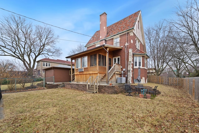 rear view of property with a fenced backyard, a yard, brick siding, a chimney, and a patio area