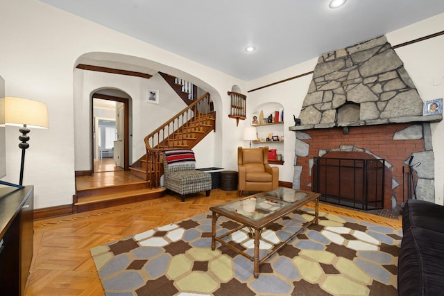 living room with recessed lighting, stairway, arched walkways, a large fireplace, and baseboards