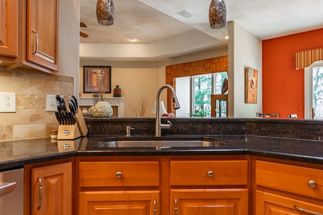 kitchen featuring visible vents, dark stone counters, a sink, decorative backsplash, and dishwasher