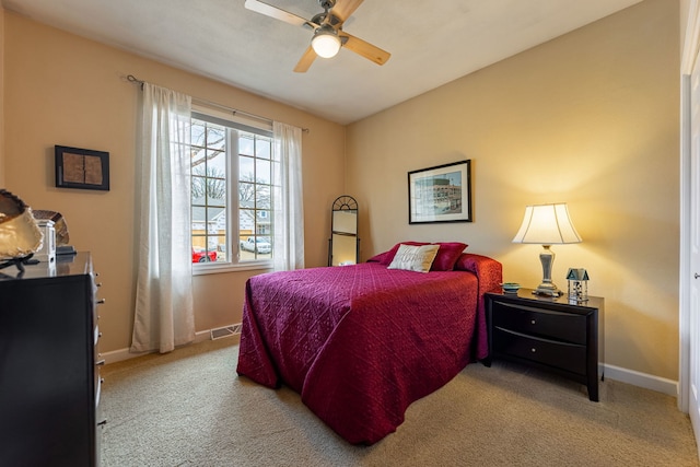 carpeted bedroom with visible vents, baseboards, and ceiling fan