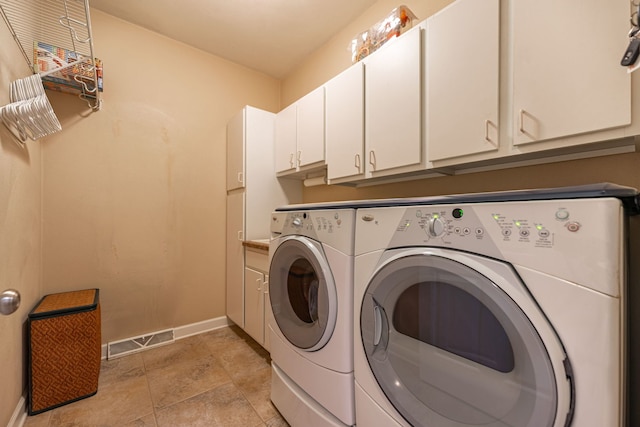 clothes washing area featuring visible vents, cabinet space, baseboards, and washer and clothes dryer