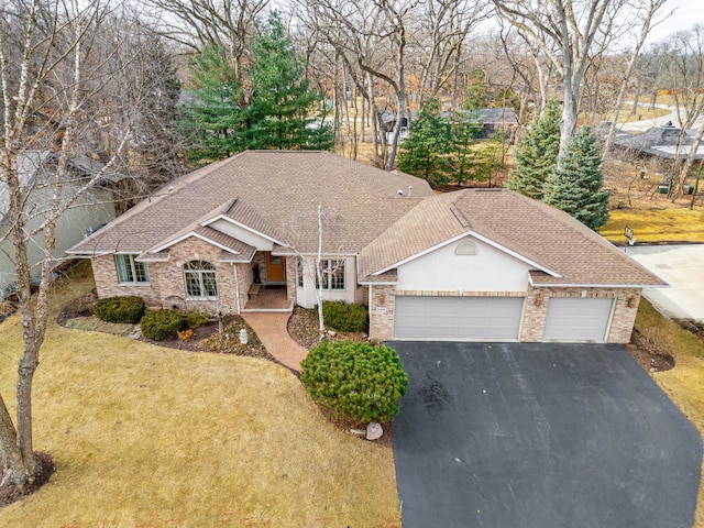 single story home featuring aphalt driveway, roof with shingles, an attached garage, a front yard, and brick siding