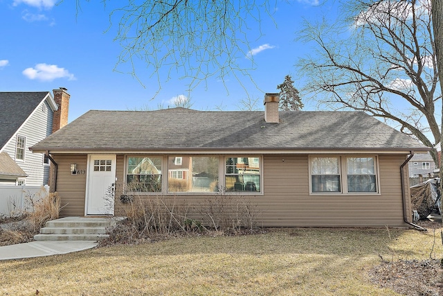 rear view of property with a chimney and a shingled roof