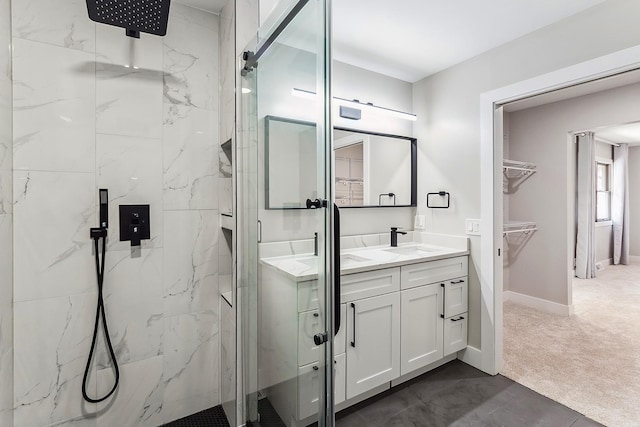 full bathroom featuring a marble finish shower, baseboards, a spacious closet, and vanity