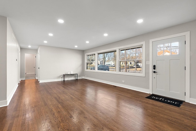 foyer entrance with dark wood finished floors, recessed lighting, and baseboards