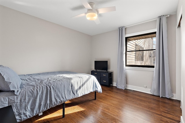 bedroom featuring ceiling fan, baseboards, and wood finished floors