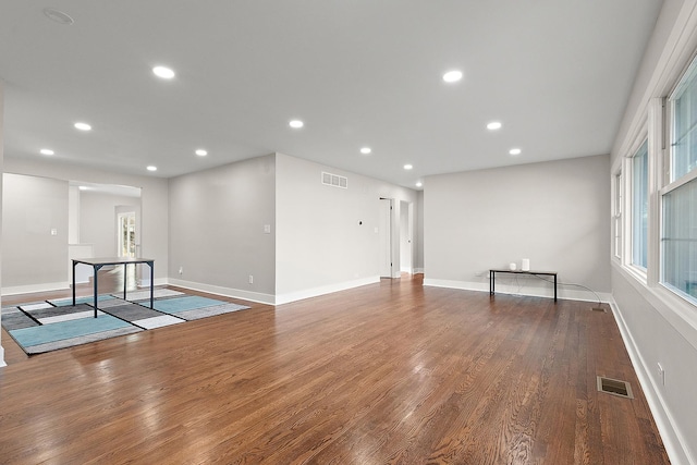 unfurnished room featuring recessed lighting, wood finished floors, visible vents, and baseboards