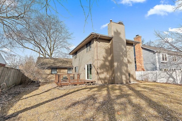 back of house with a deck, fence private yard, and a chimney