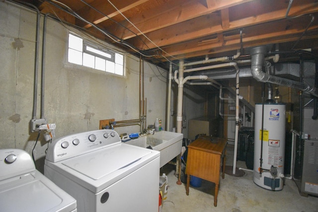 laundry area featuring laundry area, water heater, washer and clothes dryer, and a sink