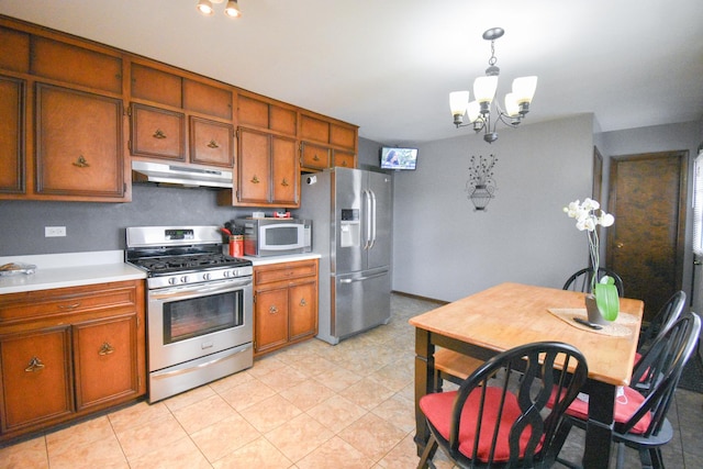 kitchen with stainless steel appliances, brown cabinetry, light countertops, and under cabinet range hood