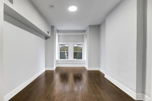 interior space with dark wood-style floors, visible vents, and baseboards