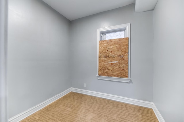 unfurnished room with baseboards