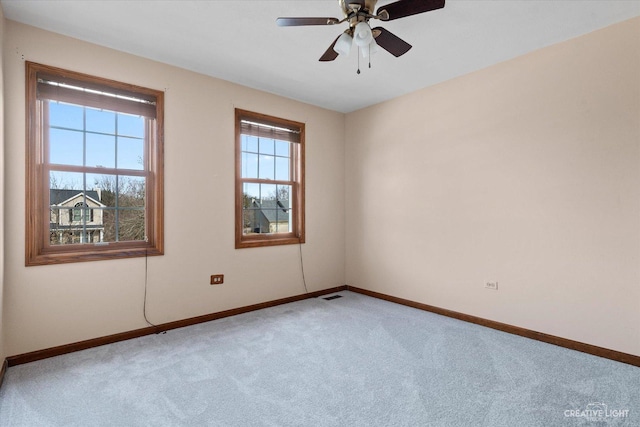 unfurnished room with visible vents, ceiling fan, baseboards, and carpet