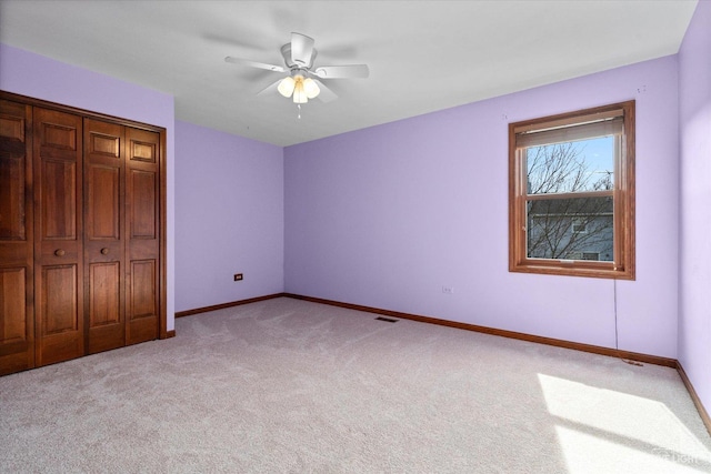 unfurnished bedroom with visible vents, baseboards, ceiling fan, light colored carpet, and a closet