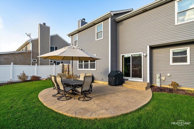 back of property featuring entry steps, a patio area, a yard, and fence