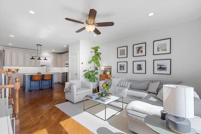 living room featuring ceiling fan, stairs, wood finished floors, and recessed lighting