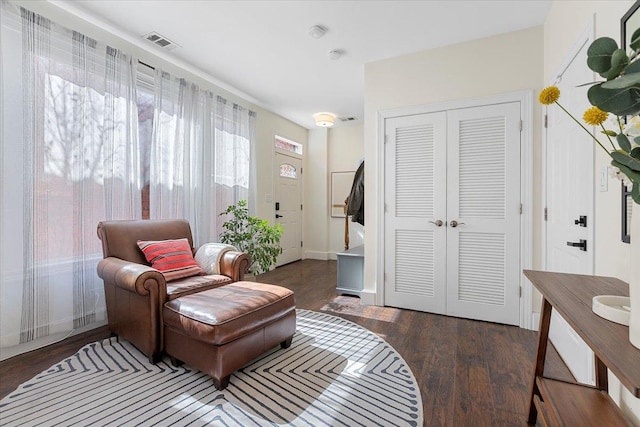 sitting room with baseboards, visible vents, and wood finished floors