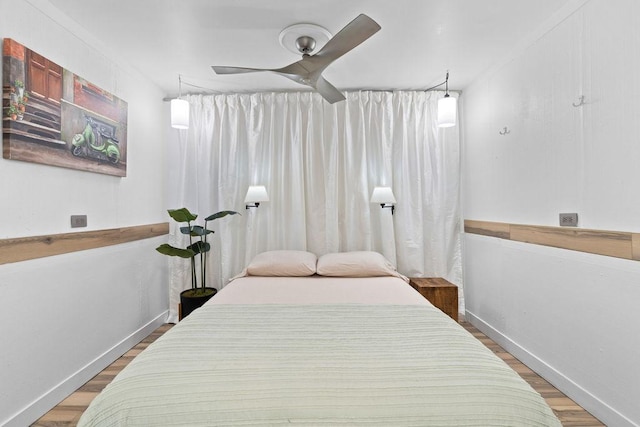 bedroom featuring wood finished floors, baseboards, and ceiling fan