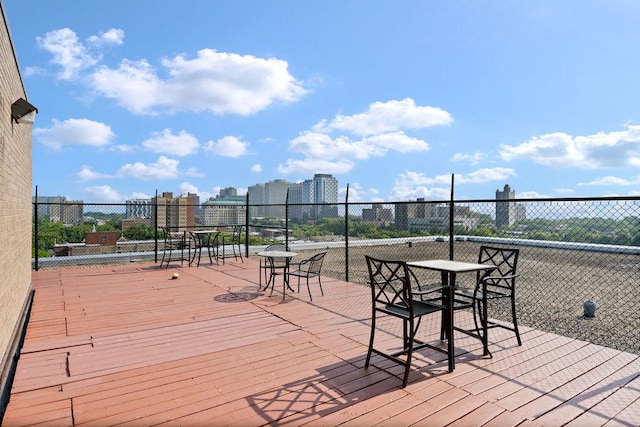 wooden deck with outdoor dining space and fence