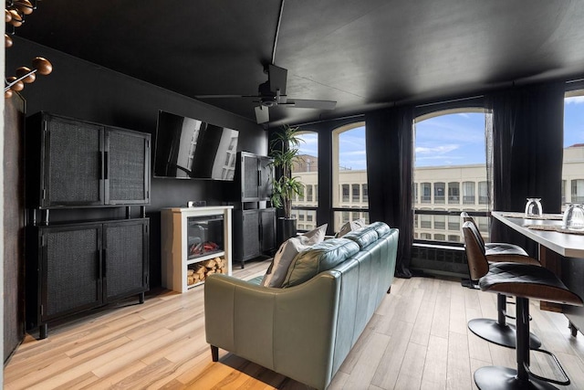 living room with a ceiling fan and light wood finished floors