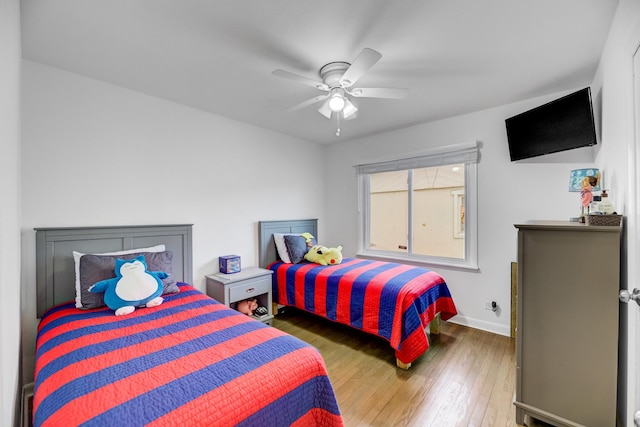 bedroom featuring ceiling fan, hardwood / wood-style flooring, and baseboards