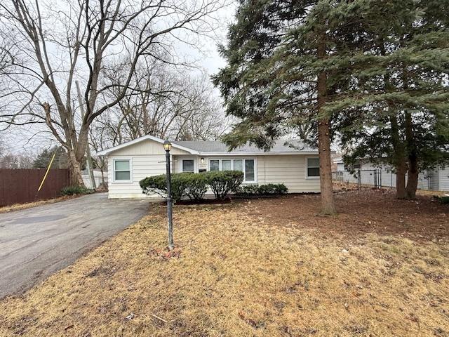 ranch-style house with driveway and fence